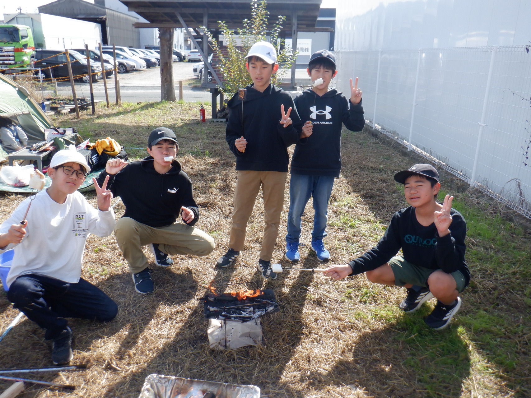 焚き火でマシュマロを焼き食べる子供たち